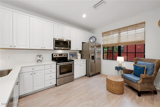 kitchen featuring light hardwood / wood-style floors, sink, stainless steel appliances, and white cabinetry