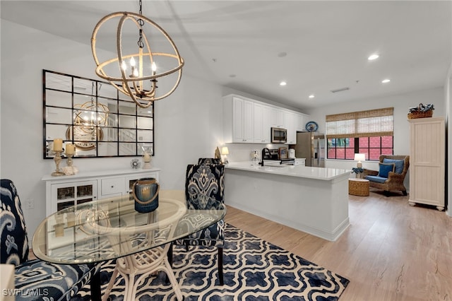 dining room with an inviting chandelier and light hardwood / wood-style floors