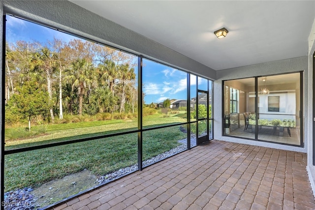 unfurnished sunroom featuring a chandelier