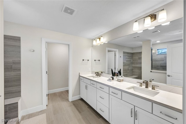 bathroom with vanity and a tile shower