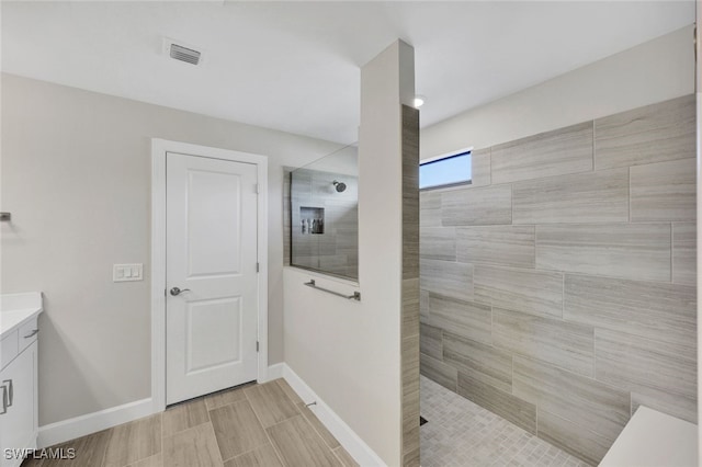 bathroom featuring vanity and a tile shower