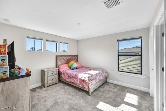 bedroom with light colored carpet and multiple windows