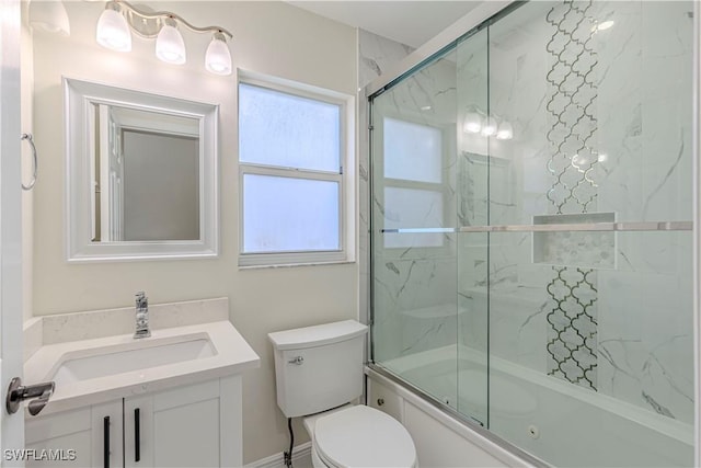 full bathroom with enclosed tub / shower combo, vanity, and toilet