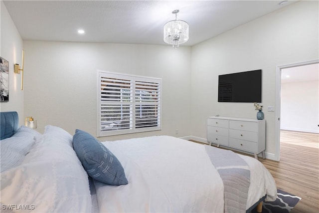 bedroom featuring light wood-type flooring and an inviting chandelier