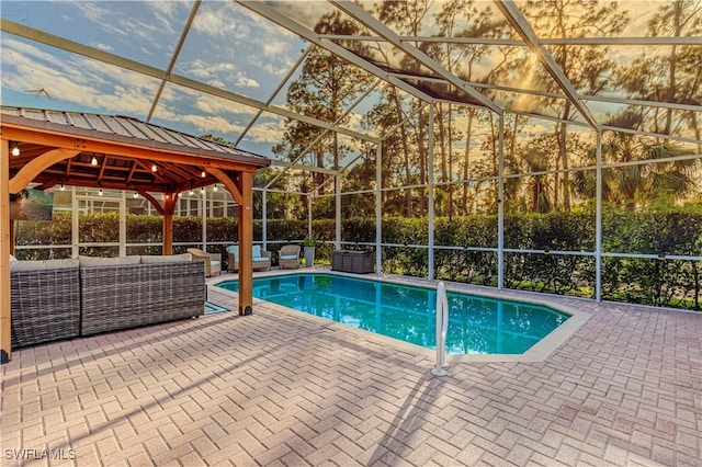 view of pool with outdoor lounge area, a gazebo, a lanai, and a patio