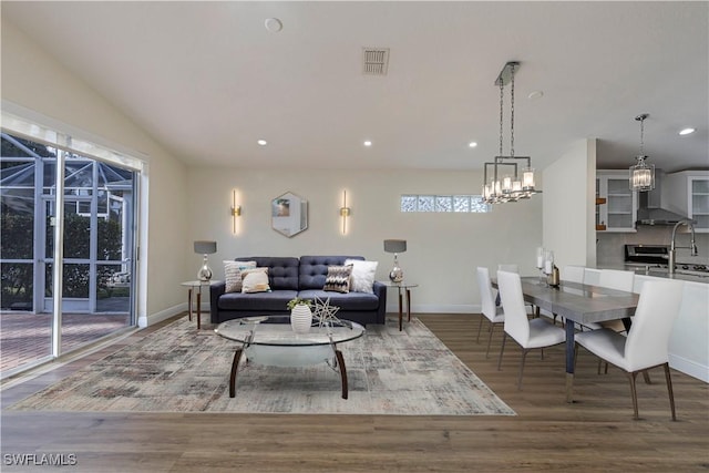 living room featuring wood-type flooring, lofted ceiling, and a healthy amount of sunlight