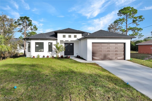 prairie-style home featuring a garage and a front lawn