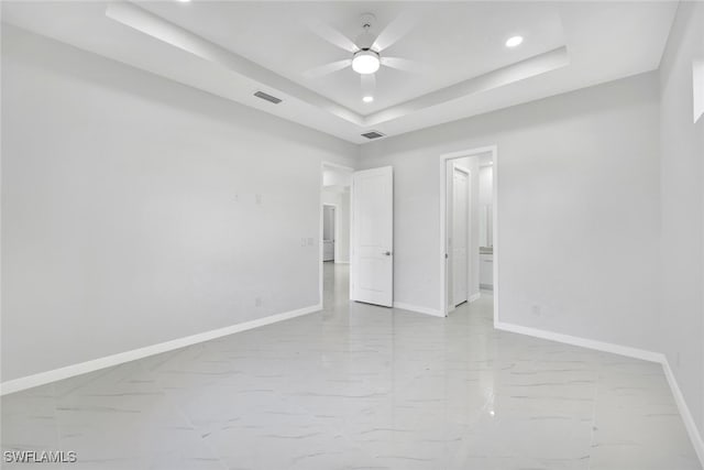 interior space with a raised ceiling and ceiling fan