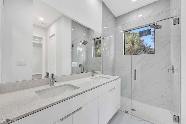 bathroom with a shower with door and vanity