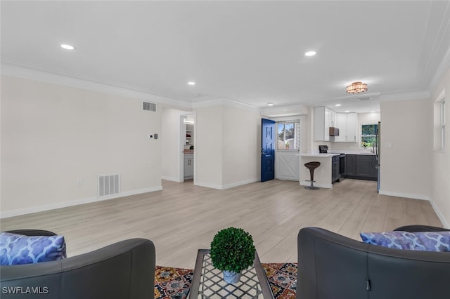 living room with crown molding and light wood-type flooring