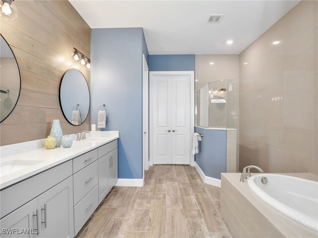 bathroom with independent shower and bath and vanity