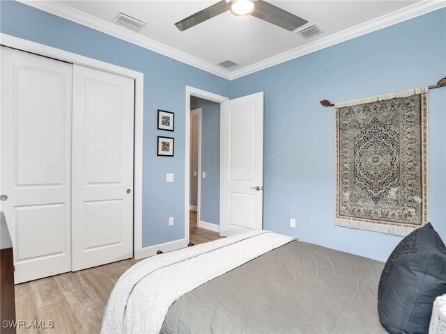 bedroom with ceiling fan, a closet, ornamental molding, and light hardwood / wood-style flooring