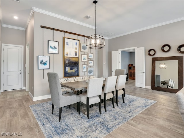 dining room featuring a notable chandelier, crown molding, and light hardwood / wood-style floors