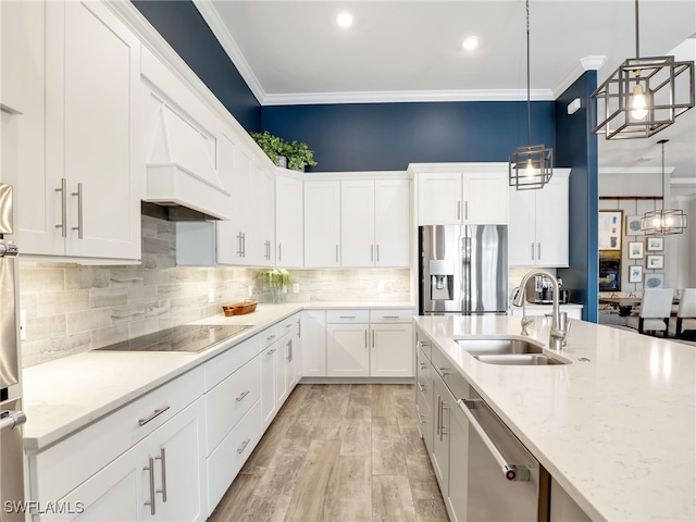 kitchen featuring appliances with stainless steel finishes, decorative light fixtures, white cabinetry, sink, and light stone counters