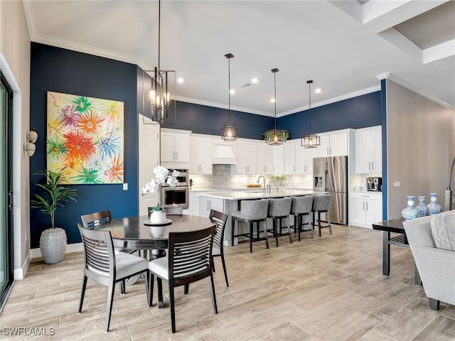 dining space with sink and crown molding