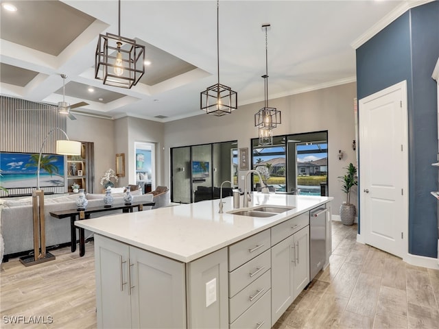 kitchen with a center island with sink, ceiling fan, hanging light fixtures, stainless steel dishwasher, and sink