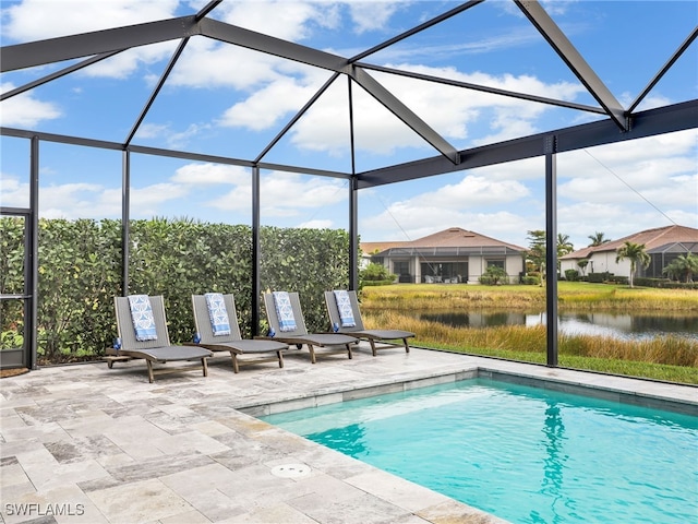 view of pool with a lanai, a patio area, and a water view