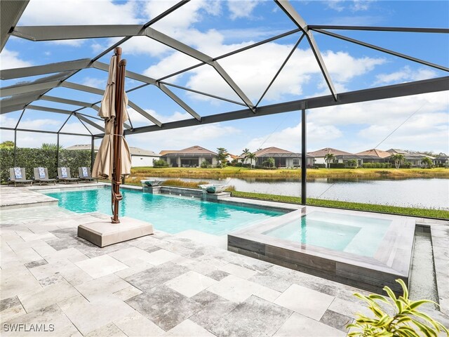 view of pool with glass enclosure, an in ground hot tub, a water view, a patio, and pool water feature