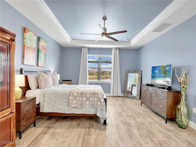 bedroom with ceiling fan, a tray ceiling, and crown molding