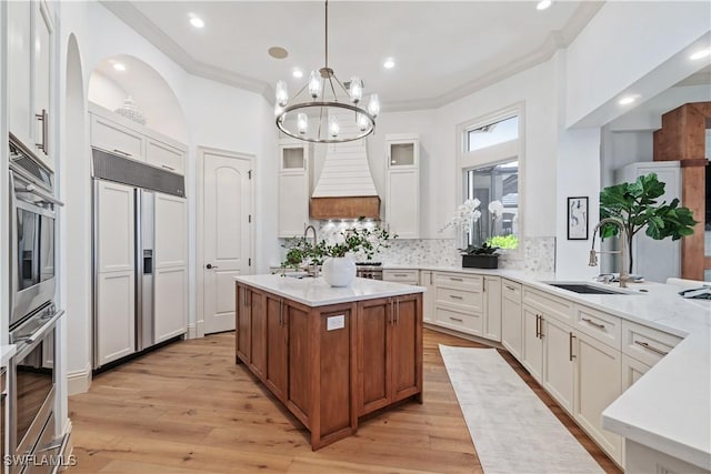 kitchen featuring light stone counters, white cabinetry, sink, and paneled fridge