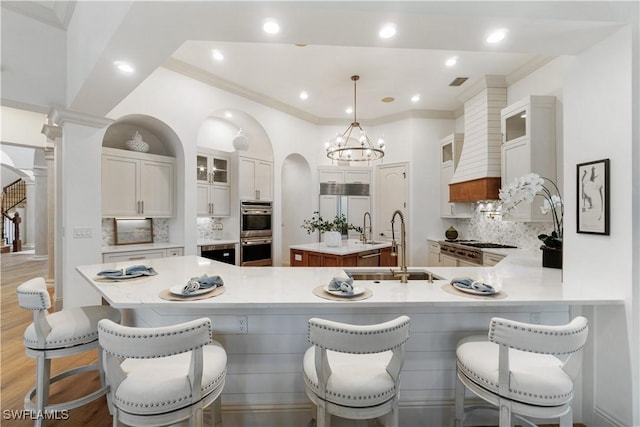 kitchen with white cabinetry, a kitchen bar, pendant lighting, and a kitchen island