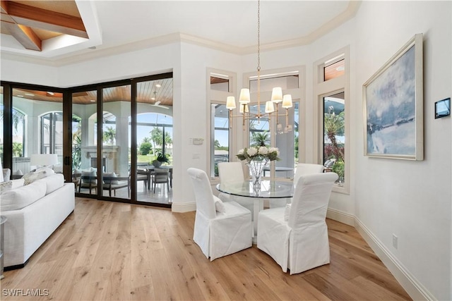 dining room featuring ornamental molding, an inviting chandelier, and light wood-type flooring