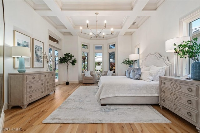 bedroom with multiple windows, beam ceiling, and light hardwood / wood-style flooring