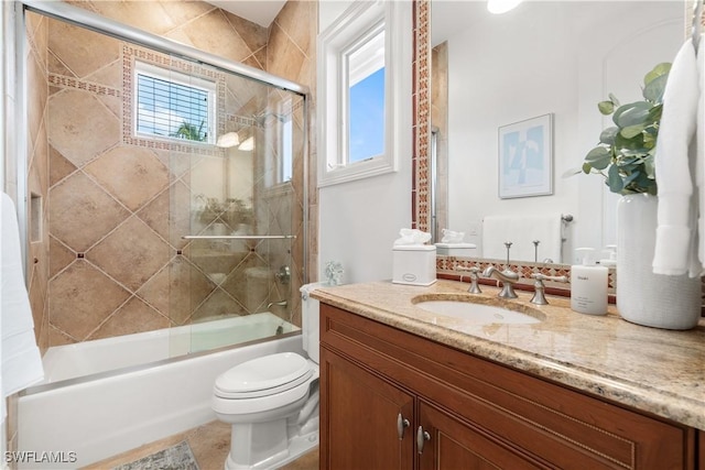 full bathroom featuring vanity, enclosed tub / shower combo, and toilet