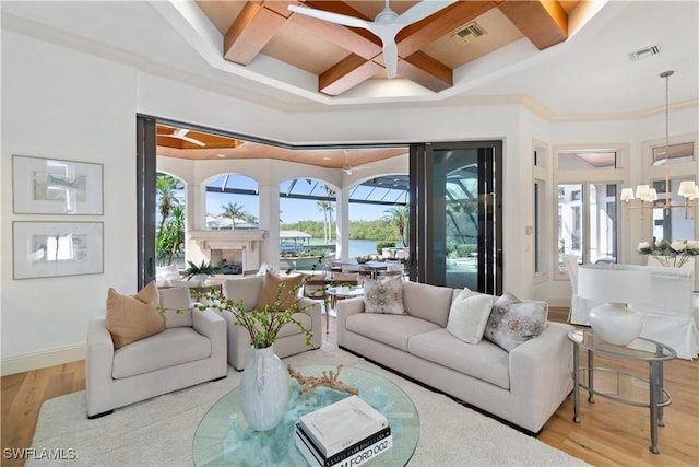 living room featuring beam ceiling, coffered ceiling, ceiling fan with notable chandelier, and light hardwood / wood-style floors