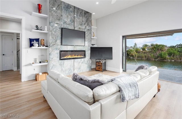 living room featuring light hardwood / wood-style floors and a tiled fireplace