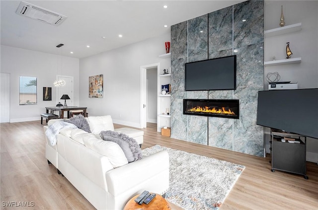 living room featuring light hardwood / wood-style floors and a tile fireplace