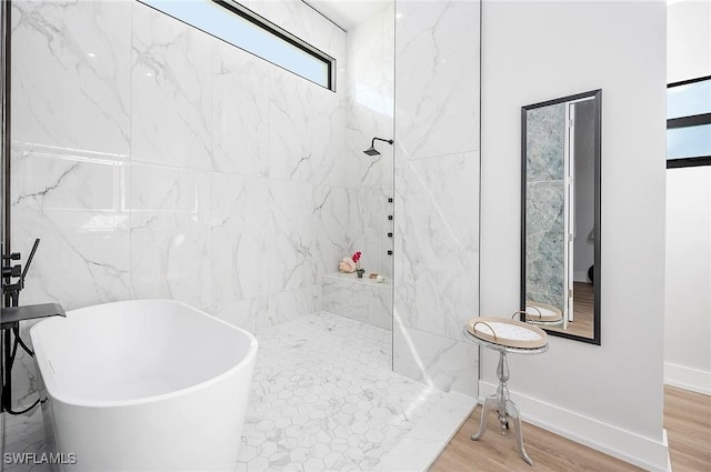 bathroom featuring wood-type flooring and shower with separate bathtub