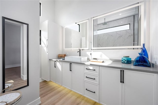 bathroom with walk in shower, vanity, and hardwood / wood-style flooring