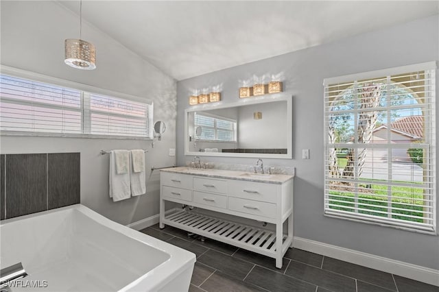 bathroom with a tub to relax in, vanity, and lofted ceiling