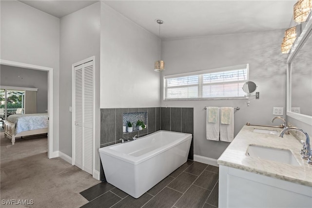 bathroom with vanity, lofted ceiling, and a bath