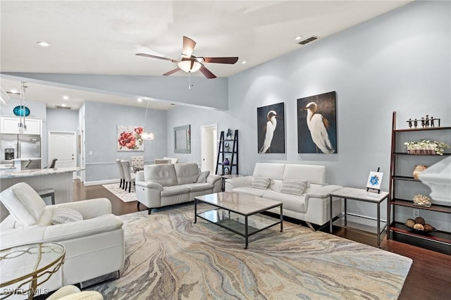 living room with ceiling fan, vaulted ceiling, and dark hardwood / wood-style floors