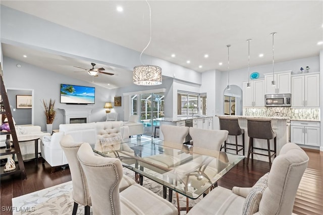 dining area featuring dark wood-type flooring, ceiling fan, and lofted ceiling