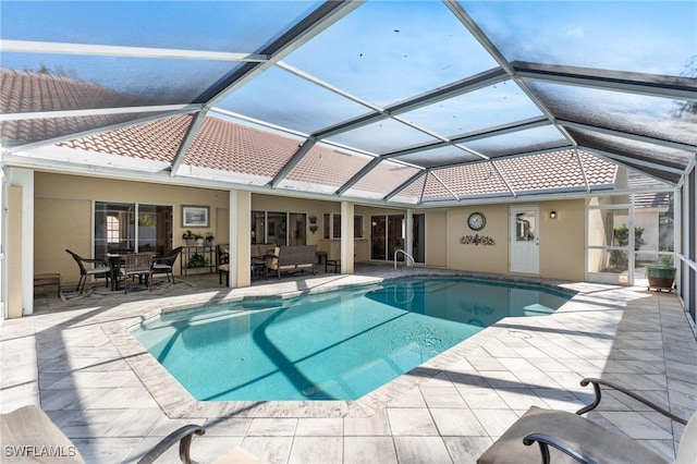 view of pool with an outdoor living space, a patio area, and glass enclosure