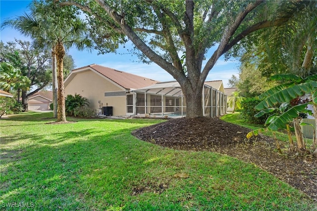 view of yard featuring a lanai and central air condition unit