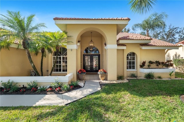 property entrance featuring a lawn and french doors