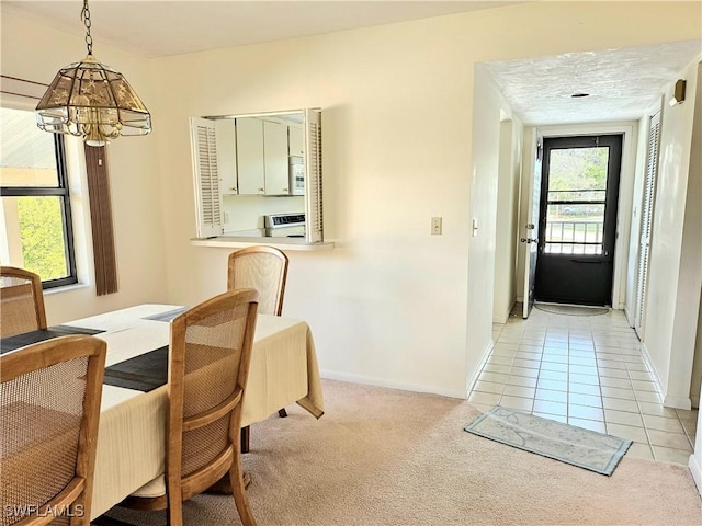 dining room featuring light colored carpet and an inviting chandelier