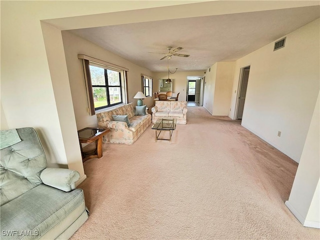 living room with ceiling fan and light colored carpet