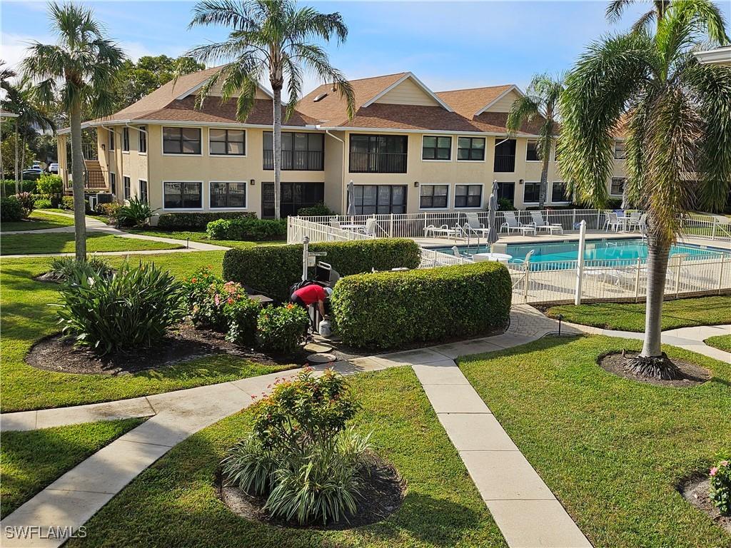 1100 9th St S Unit F203, Naples, FL 34102 - view of community featuring a pool and a yard