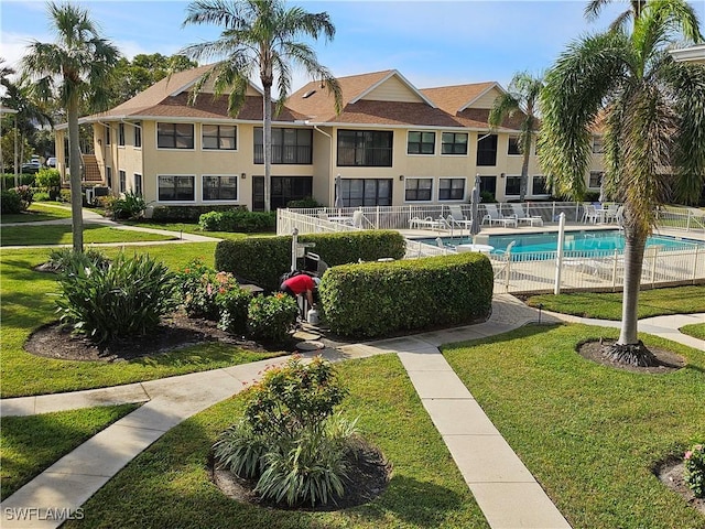 view of community featuring a pool and a yard