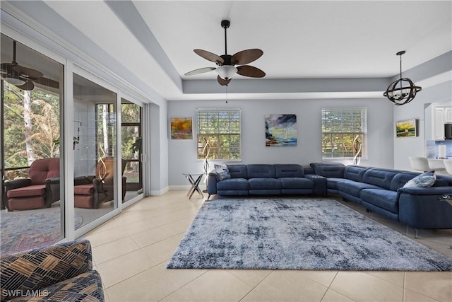 living room with light tile patterned floors and ceiling fan with notable chandelier