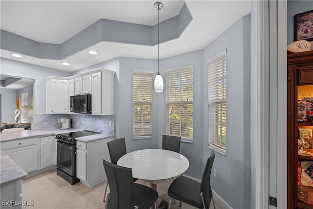 kitchen featuring decorative light fixtures, black appliances, decorative backsplash, light tile patterned floors, and white cabinets