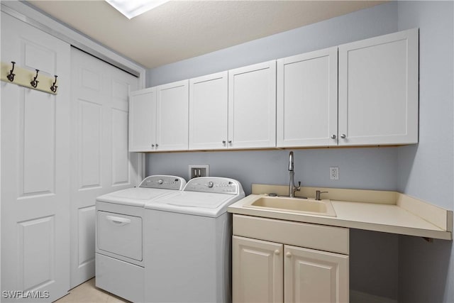 laundry room featuring cabinets, independent washer and dryer, and sink