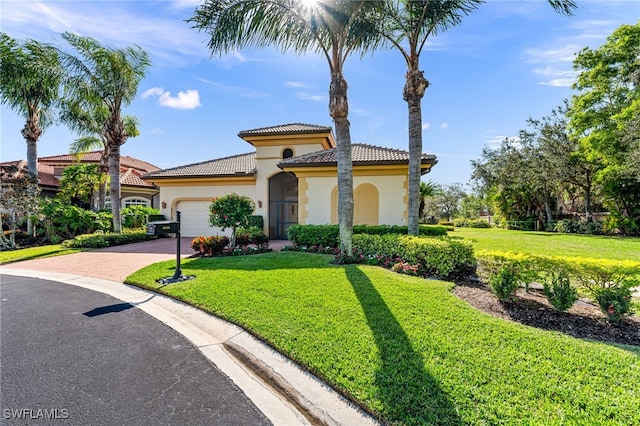 mediterranean / spanish-style house featuring a garage and a front yard