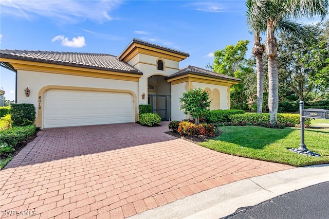 mediterranean / spanish-style home featuring a front yard and a garage