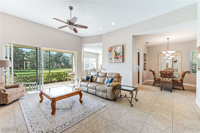 living room with light tile patterned flooring and ceiling fan with notable chandelier